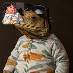 A chubby baby dressed in a dinosaur-patterned onesie lounges with oversized sunglasses perched on their head, looking off to the side with a curious expression. The text overlay above asks 'todo bien wey?', adding a humorous touch to the cozy indoor scene.