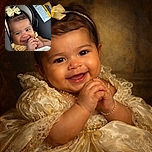 A smiling baby with a cute yellow bow on her head and a matching outfit, sitting comfortably in a car seat, clasping her hands together with a playful expression and bright eyes, wrapped partially in a soft white blanket.