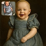 A joyful baby wearing a delicate blue dress with embroidered details is lying on a textured gray blanket, smiling widely with bright eyes and a playful tongue out, resting on a pillow with a cute pink skull design.