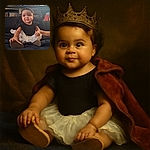 A cute baby dressed in a black top and white tutu skirt sits comfortably on a dark couch, smiling slightly with bright eyes that sparkle with curiosity. The background shows a shelf with various household items, including glasses and mugs, adding a cozy home vibe.