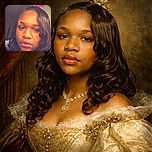 A close-up selfie of a young person with shiny, curled hair and glossy lips, set against a neutral indoor background with a pink flower decoration peeking from behind.