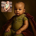 A chubby-cheeked baby in a light green romper with a colorful bird patch sits comfortably on a brown leather couch, looking curiously at the camera with wide eyes and a slight smile, exuding adorable innocence.