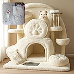 A fluffy white cat is curled up peacefully on a soft beige blanket, showing off its adorable pink paw pads in a cozy nap spot.