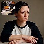 A relaxed black and white dog lounges comfortably on a soft, fluffy blanket draped over a cozy chair, surrounded by a cluttered background of boxes and household items, capturing a candid moment of pet tranquility.