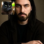 A majestic black cat with piercing green eyes stares intensely at the camera, its fluffy fur creating a regal mane. The background shows a cozy room with a cabinet and a bright green aquarium, adding a homely touch to this feline portrait.