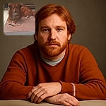 A slightly blurry photo of a brown dog with white paws lying on a pink cushion in a room with tiled floor and some furniture in the background. The dog's eyes reflect light, giving a glowing effect.