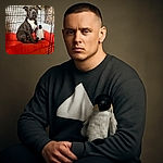 A dignified dog sits attentively inside a cozy crate lined with a bright orange cushion, accompanied by a plush penguin toy and a hanging stuffed animal in the background, creating a snug and charming pet retreat.