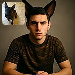 A curious brindle dog with huge, upright ears sits attentively on a tiled floor, looking up as if expecting a treat or a belly rub.
