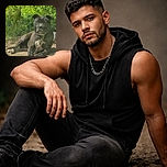 A dignified black dog lounges on a dirt patch surrounded by lush green foliage, looking like the king of the backyard jungle. The photo has a slight haze and some glare, adding a mysterious vibe. There's a small, clear text overlay in the bottom right corner that reads 'Forbidden Kemono,' giving the image a quirky title.