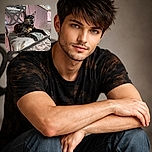 A striking tortoiseshell cat lounges regally on a vintage cushioned chair, its bright yellow eyes gleaming with curiosity as it surveys the rustic patio setting with a mix of elegance and attitude.