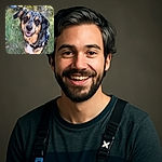 A charming dog with a speckled black and tan coat, wearing a blue harness, smiles warmly at the camera in a sunlit outdoor setting with blurred greenery in the background, capturing a moment of joyful canine friendliness.