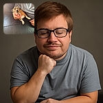 A small dog lounging on a black leather couch, wearing oversized glasses perched comically on its nose, while being gently held by a person in a gray shirt. The lighting casts a warm glow, creating a cozy and humorous scene.
