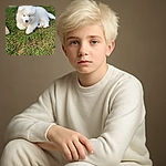 A fluffy white puppy lounges on a patch of green grass near a wall and gravel, looking adorably calm and cozy with a slightly curious expression. Another similar fluffy figure is partly visible on the right side, suggesting a playful duo.