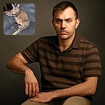A chubby tabby cat lounges comfortably on a gray fabric couch, stretching its paws out with a slightly serious and intense gaze, as if guarding its cozy kingdom.