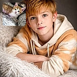 A fluffy orange and white kitten lounges comfortably on a soft, shaggy gray blanket, its big curious eyes sparkling as it gazes directly at the camera, capturing a moment of innocent feline charm.