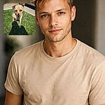 A curious dog with one ear perked up stands on a bright green lawn, staring intently at the camera with soulful eyes. The shadow of the photographer stretches across the grass, adding a humorous human silhouette to the sunny suburban scene.