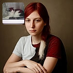 A black and white cat is lounging comfortably behind a slightly foggy window, with curtains draped to the side creating a cozy indoor scene. The photo has a soft, muted quality due to the glass reflection and lighting.