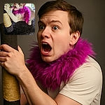A lively cat sporting a vibrant pink feather boa is caught mid-meow while scratching a sisal-wrapped post on a plush dark carpeted cat tree, with a slightly blurred background showing a window and some colorful items.
