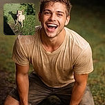 A happy dog stands on a grassy lawn, looking up eagerly with its mouth open as if ready to play fetch. The dog's shadow is cast clearly on the grass, and the sunlight highlights its wet fur. The surrounding grass is lush and green with patches of dirt.