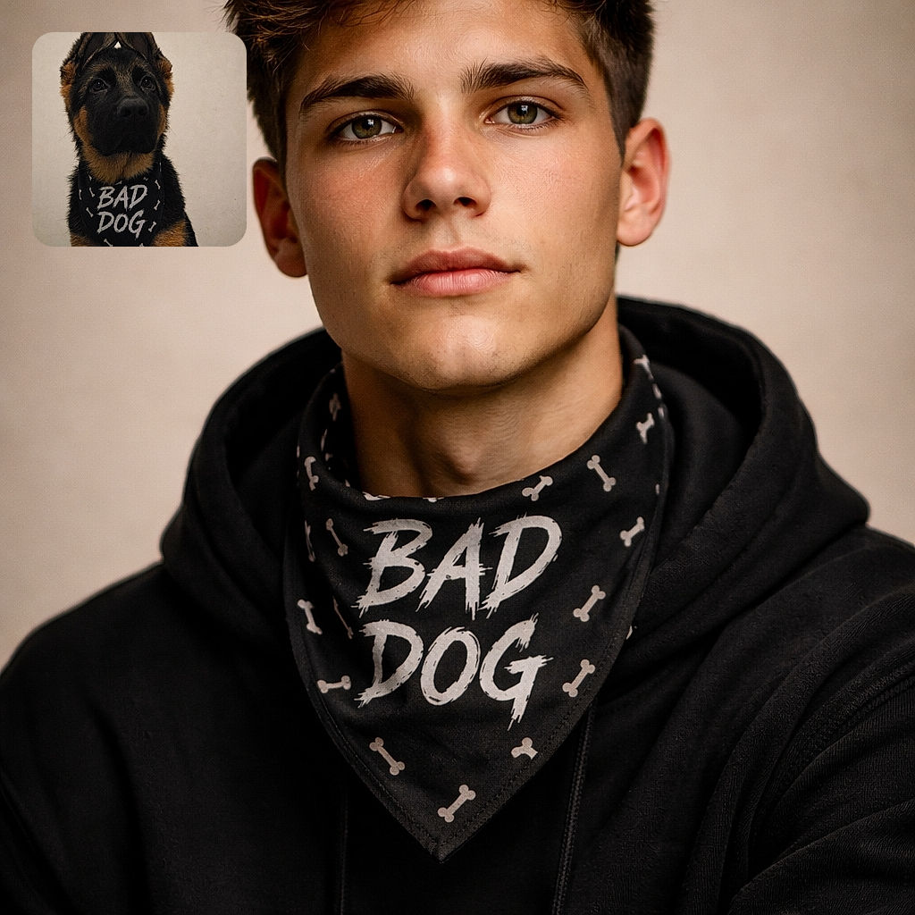 A serious-faced German Shepherd puppy wearing a cheeky 'BAD DOG' bandana, with its ears adorably folded back, staring intently against a plain background, making mischief look stylish.