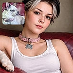 A small white and black dog with big ears lounges on a shiny red leather couch, looking off to the side with a curious expression, wearing a pink collar with a bone-shaped tag.