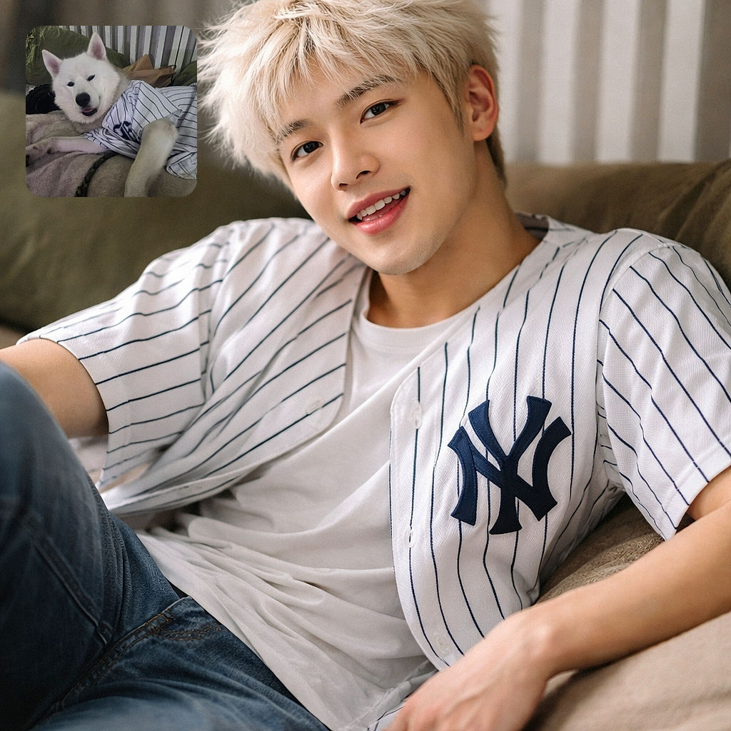 A fluffy white dog lounging comfortably on a bed, wearing a striped shirt that makes it look like it's ready for a baseball game, with a cozy and slightly cluttered background.