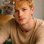 A close-up photo of a light brown cat with soft fur and expressive eyes, looking contemplative. The background is blurred, drawing attention to the cat's detailed face and whiskers.