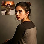 A charming Siamese cat sits on a cozy carpet, gazing back with big, curious eyes, warmed by the soft glow of a crackling fireplace in the background. The scene radiates comfort and tranquility, like the cat is contemplating the mysteries of life or just waiting for a treat.