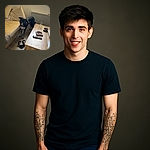 A cheerful black and white dog stands eagerly between a beige sofa and a wooden coffee table in a cozy living room. The dog looks directly at the camera with its tongue out, surrounded by comfy cushions, panda slippers on the floor, and everyday items like a remote control and a game controller on the table. Sunlight filters softly through a window, adding warmth to the scene.