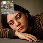A close-up of a relaxed tabby cat lying on a textured stone surface, eyes half-closed in a sleepy, contented expression, with a softly blurred garden background and warm natural light.