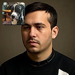 A blurry photo of a black and white dog sitting indoors with wooden furniture in the background. The image has a timestamp overlay at the top and some UI elements at the bottom, making it look like a casual snapshot taken from a phone gallery.