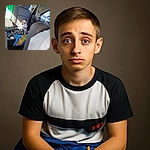 A small dog with a curious expression is sitting on a colorful blanket in the backseat of a car, surrounded by typical car interior elements and some clutter on the floor.