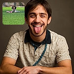 A happy dog lies on a lush green lawn with a pink toy in front of a black metal fence and rocky background, tongue out and leash loosely coiled nearby, soaking up the outdoor vibes.