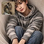 A charming tabby cat with big, curious eyes is cozily curled up inside a mesh laundry basket, looking up with an innocent and slightly mischievous expression as if plotting a playful escape.