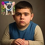 A charming pug puppy wearing a cozy denim jacket stands amidst autumn leaves with a blurred human figure in the background, creating a warm and adorable outdoor scene.