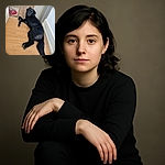 A sleek black dog lounges on a wooden floor, looking back with a curious and slightly guilty expression, as if caught mid-nap or mid-mischief near the doorway with a cozy rug peeking in the background.