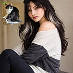 A fluffy black and white cat sits perched on a scratching post, with a slightly blurry focus giving it a soft, dreamy look. Above the cat, bright green handwriting spells out 'Little Ones,' adding a playful touch to the cozy indoor scene.