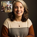 A happy dog sporting a playful unicorn headband with orange wire ears and horn, sitting in a cozy, cluttered room filled with toys, medals, and colorful decor. The dog's joyful expression and bright eyes make it look like the star of a whimsical costume party.