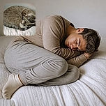 Two cozy cats are curled into an impressive synchronized nap on a quilted bed, as if practicing for the feline Olympics of maximum comfort. One appears to be using the other as a furry pillow while their paws and tails create a wonderfully tangled cuddle sculpture.