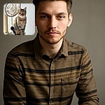 A regal tabby cat sits poised on a cozy beige cat tree, gazing intently with big yellow eyes. The soft, neutral background highlights the cat's striking stripes and the fluffy texture of the cat tree, complete with a dangling black pom-pom toy.