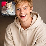 A cheerful fluffy dog with striking blue eyes is sitting on a tiled floor near a bright red door, looking up with a happy, tongue-out smile, radiating pure joy and friendliness.
