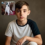 A cute puppy with a black patch over one eye sits on a cozy couch covered with blankets. The background shows some household items slightly out of focus, making the puppy the clear star of this warm, homey snapshot.