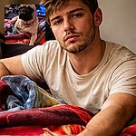 A squishy-faced pug lounges like a tiny grumpy monarch on a pile of colorful blankets while a TV blurs in the background — equal parts regal and exhausted, plotting a nap or world domination.