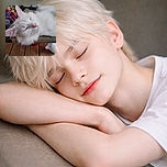A fluffy white cat is peacefully napping on a mesh chair outdoors, soaking up the calm vibes of the wooden deck and garden surroundings. Its pink nose and closed eyes add to the serene, cozy atmosphere.