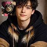 A fluffy, adorable small dog with a mix of black and tan fur gazes up with big, curious eyes surrounded by a cozy mess of blankets, a pink slipper, and a vibrant pink bin in the background, creating a warm, homey vibe.