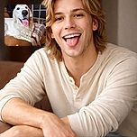 A gleeful golden retriever hogs the frame, nose and tongue front-and-center (complete with a dramatic dark spot), lounging on a couch with a cozy plaid blanket and a softly blurred living-room backdrop—looks like it's auditioning for "Goodest Boy of the Year."