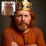 A majestic fluffy orange cat wears a regal golden paper crown, staring seriously into the camera with a royal air, while the softly lit room blurs gently in the background.