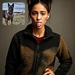 A wet German Shepherd stands proudly on a rocky shore with a playful tongue out, ready for a swim or a game by the water's edge.