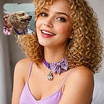 A cheerful curly-haired dog sporting a sparkly bow tie and purple collar is front and center, tongue out in a happy pant. Behind the dog, a smiling elderly woman with glasses peeks from the side, creating a warm and cozy vibe in a softly lit room with a bulletin board in the background.