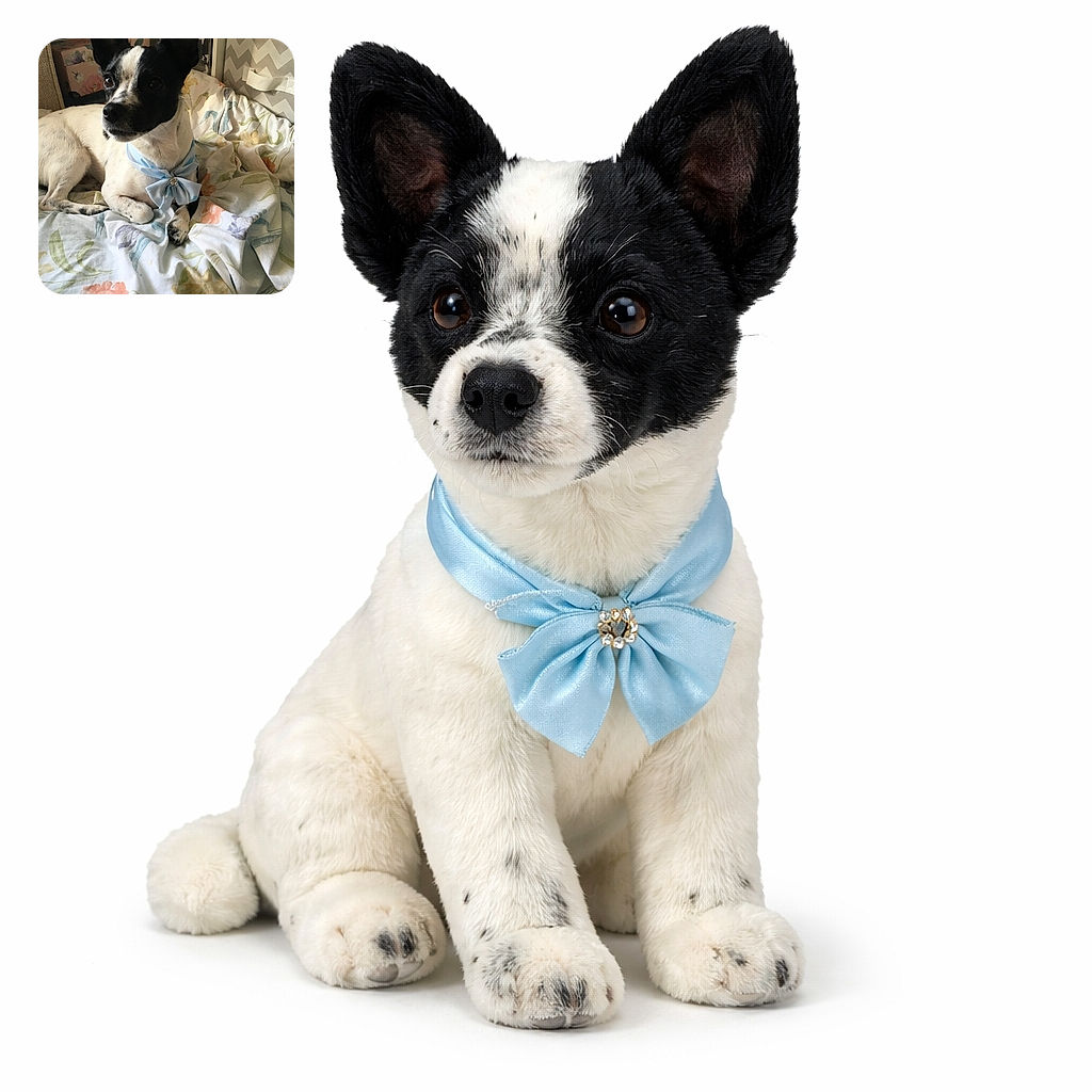A dapper little pup lounges on a floral duvet wearing a sky-blue bow like royalty — ears at attention, eyes plotting treats, and the kind of pose that demands belly rubs and applause.